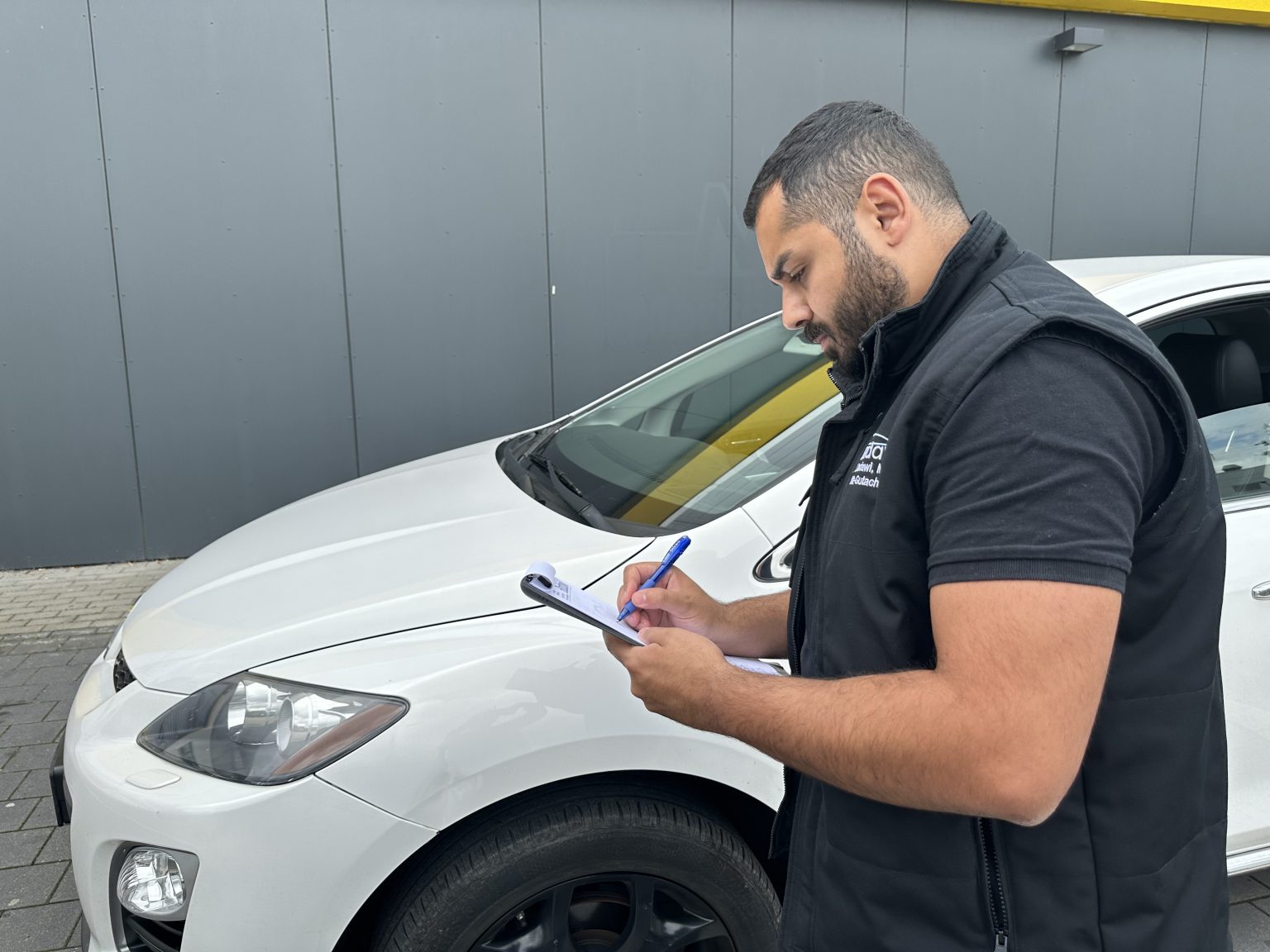 Sachverständiger notiert Daten am Fahrzeug