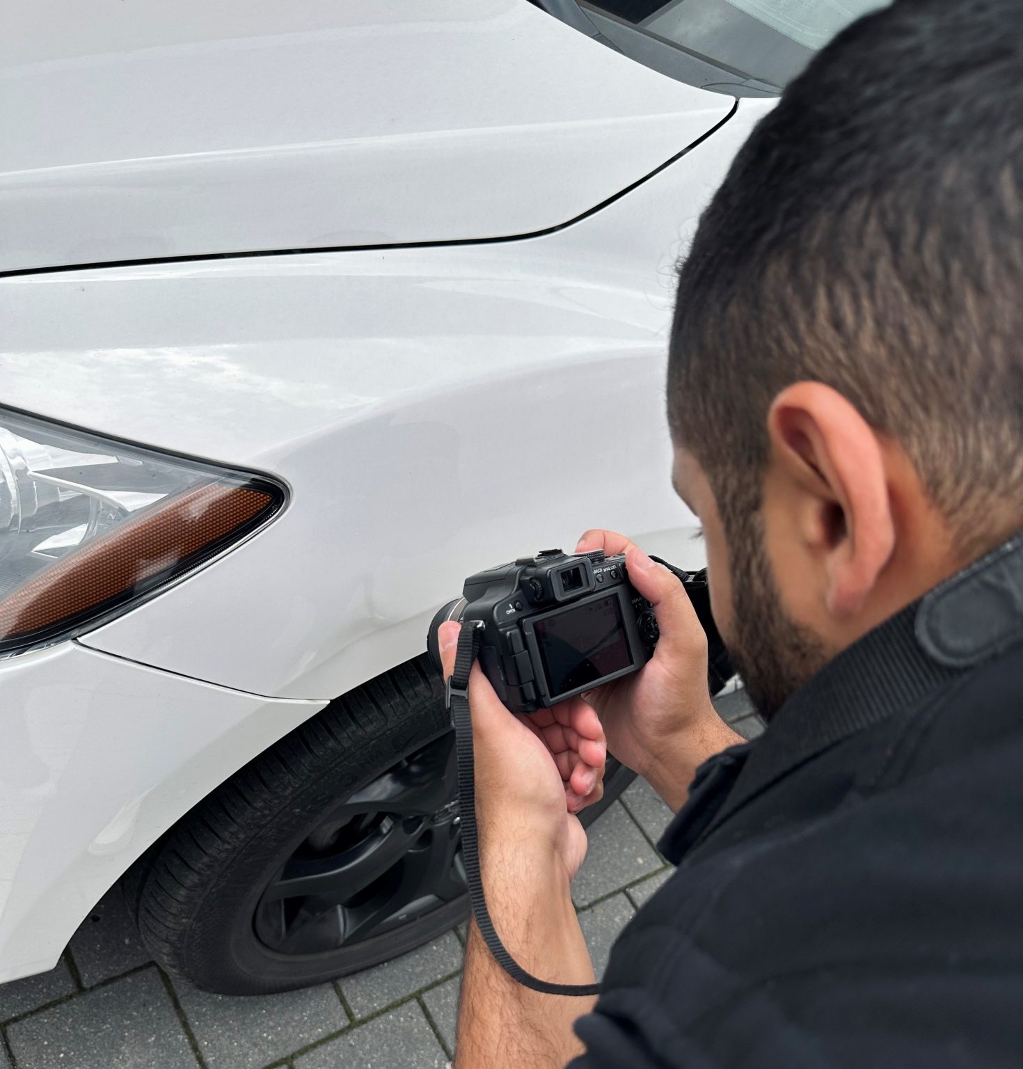 Sachverständiger fotografiert einen Schaden am Kotflügel